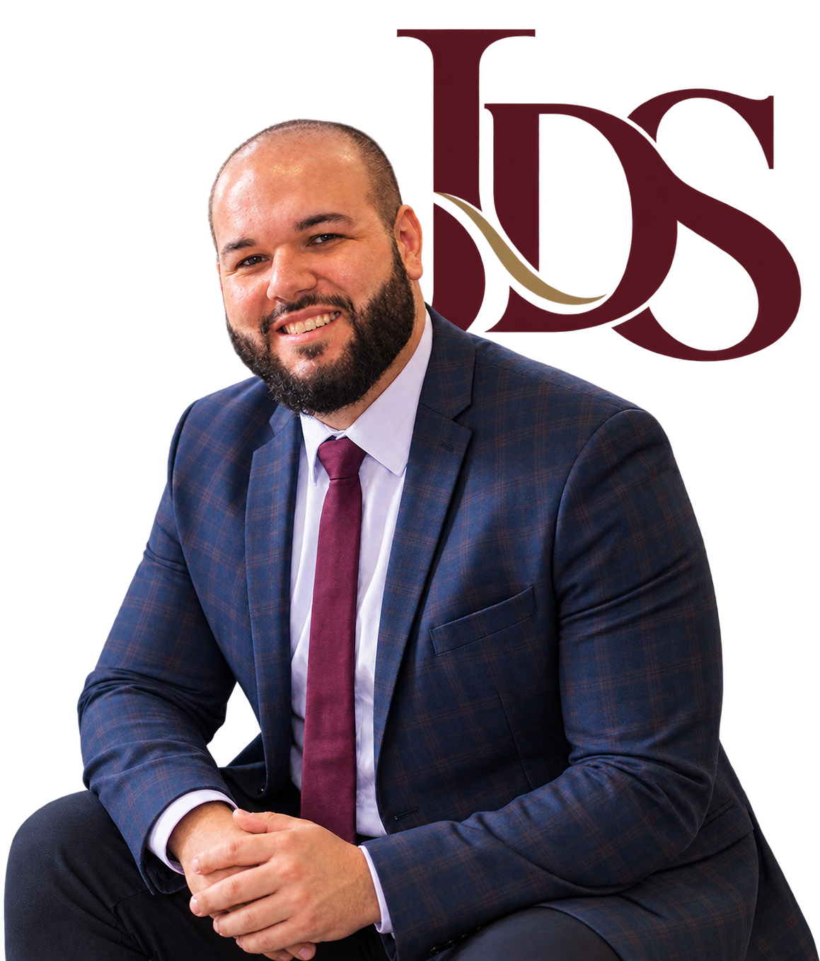 Jesus De Sousa seated in a suit, with the JDS monogram behind him